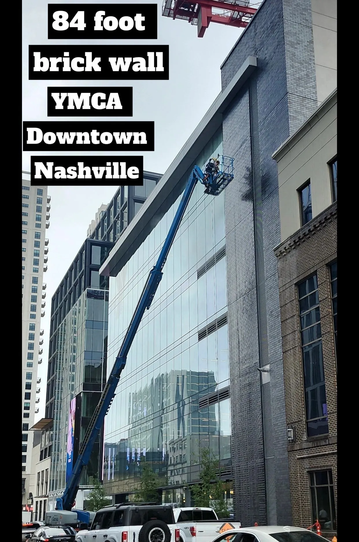 Boom lift working the upper section of the brick wall
