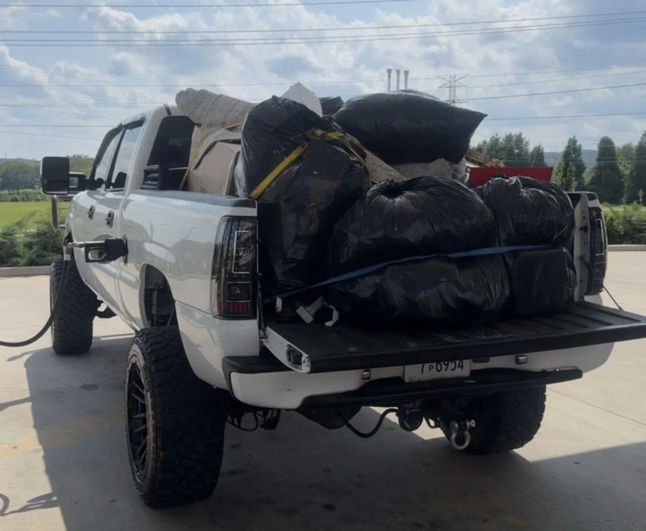 Truck bed loaded and strapped with bagged household junk for the dump